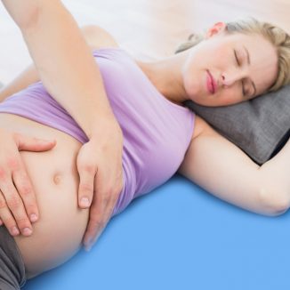 Peaceful pregnant woman having a relaxing massage in a studio